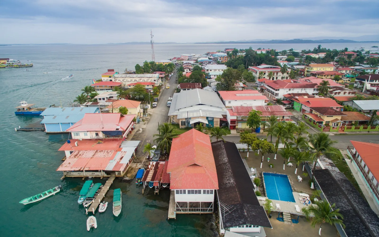 Luftaufnahme von Bocas Town mit Pfahlbauten und Bootsstegen am Wasser.