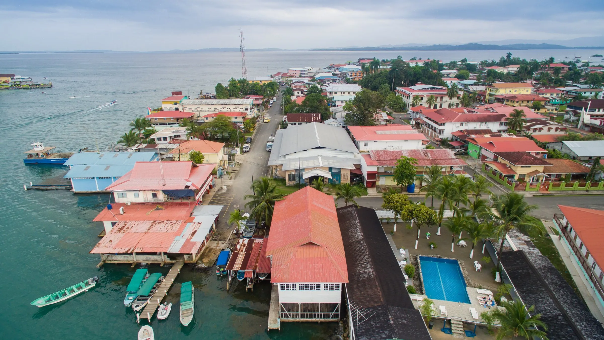 Luftaufnahme von Bocas Town mit Pfahlbauten und Bootsstegen am Wasser.