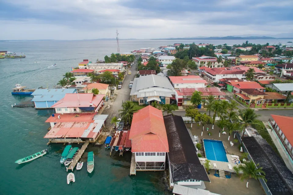 Luftaufnahme von Bocas Town mit Pfahlbauten und Bootsstegen am Wasser.