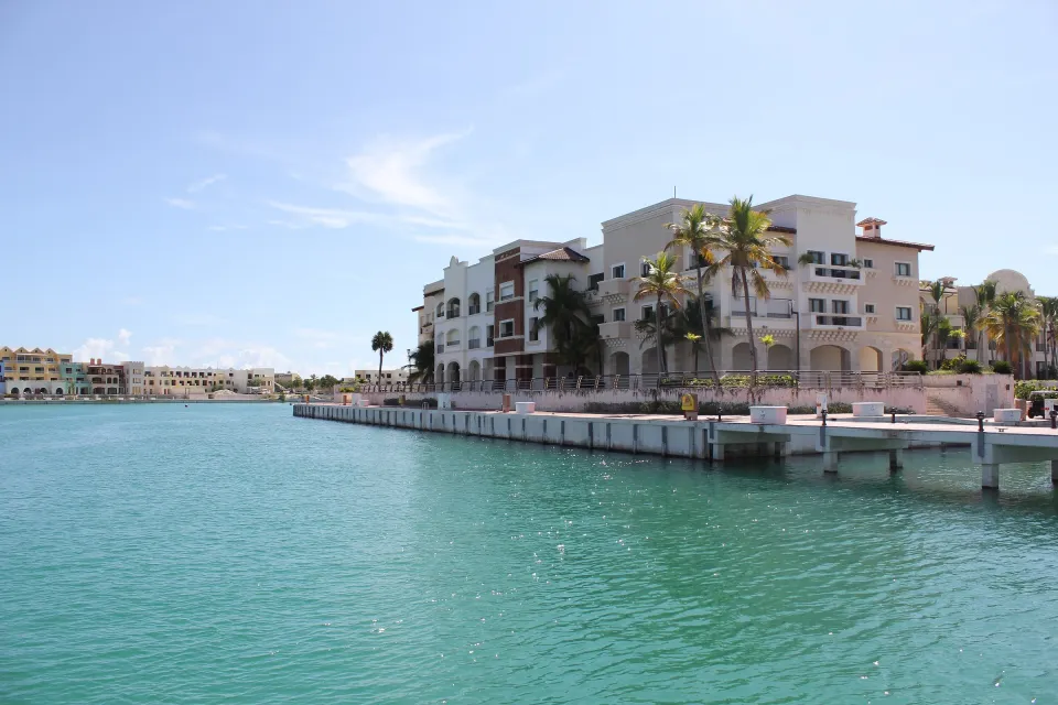 Die Marina von Cap Cana mit Booten, Steg und Wohngebäuden am Wasser.