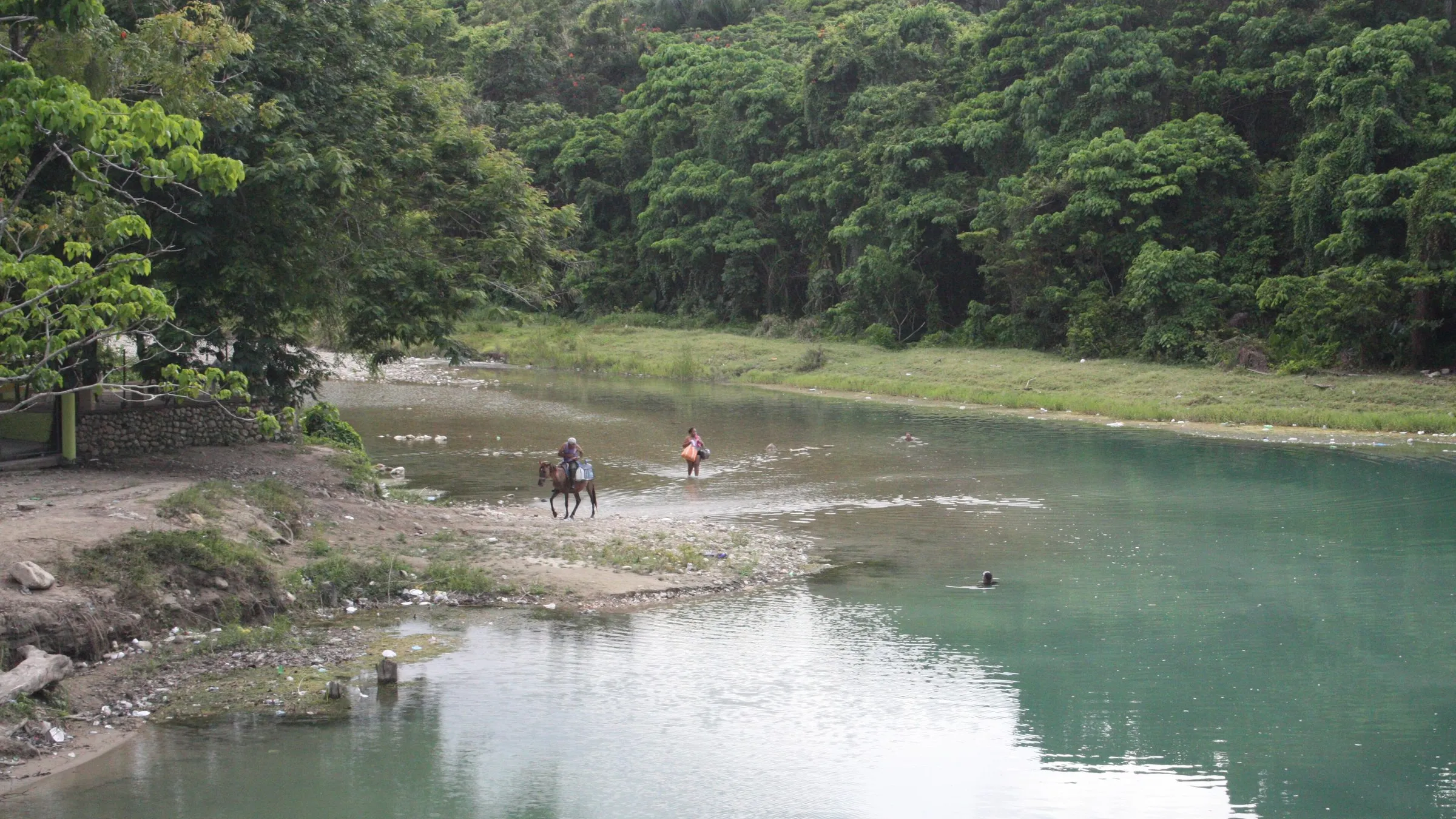 Der ruhige Fluss bei La Confluencia in Jarabacoa, umgeben von dichtem Wald.
