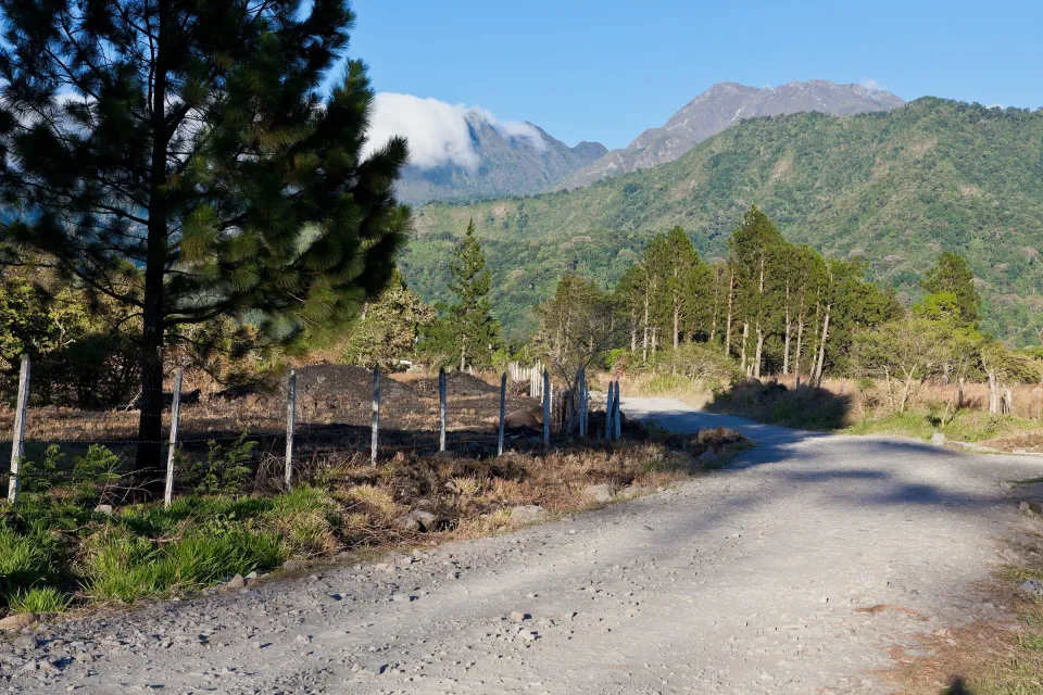 Der Gipfel des Vulkans Barú über Kiefern und einer Landstraße bei Volcán.